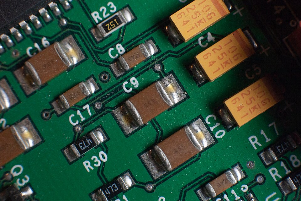 PCB 기판에 실장된 세라믹 커패시터와 기타 전자 부품들